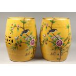 A PAIR OF CHINESE YELLOW POTTERY BARREL SEATS painted with birds and flowers. 17ins high.
