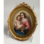 A GOOD 19TH CENTURY CONTINENTAL PORCELAIN OVAL GILT FRAMED PLAQUE, Madonna and child. 9ins x 7ins.