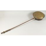 A 17TH - 18TH CENTURY DUTCH BRASS CIRCULAR WARMING PAN with metal handle. 42ins long.