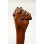 A FOLK ART CLENCHED FIST WALKING STICK 35ins long.