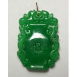 A CHINESE CARVED JADE URN-SHAPED PENDANT with gold rim, 5cm