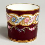 A SEVRES LARGE COFFEE CAN PAINTED WITH CHAINS OF RIBBONS AND FLOWERS on a claret ground, marked with