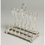A SILVER-PLATED SIX DIVISION TOAST RACK with cross golf clubs.