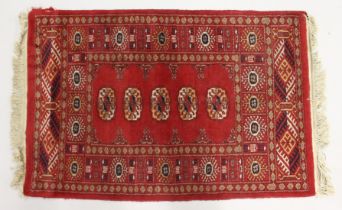 A SMALL BOKHARA RUG, with a single row of five medallions. 3ft 3ins x 2ft 2ins.