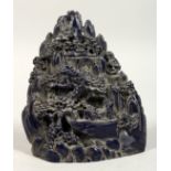 A CHINESE CARVED FAUX-LAPIS BOULDER, trees, figures, and boats. 7ins high.