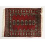 A SMALL BOKHARA RUG, with a single row of five medallions. 2ft 8ins x 2ft 1ins.