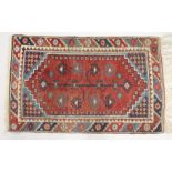 A SMALL PERSIAN RUG, red ground with geometric decoration. 4ft x 2ft 6ins.