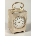 A MINIATURE SILVER CASED CLOCK in a plain case with carrying handles and ball feet. 3.5ins high,