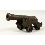 A SMALL EARLY BRONZE STARTER CANNON on bronze stand. 10ins long.