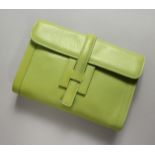 A GREEN LEATHER CLUTCH BAG and strap. 24cm long x 17cm high.