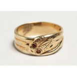 A 9CT GOLD SNAKE RING set with ruby eyes