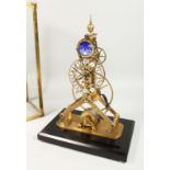 A MOONPHASE BRASS SKELETON CLOCK. 15ins high in a glass case.