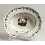 A CONTINENTAL TIN GLAZE SHAVING DISH, the centre painted with a cottage and flowers. 13ins long.