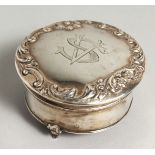 A CIRCULAR SILVER BOX on three curving feet, 3ins diameter. Birmingham, 1909.