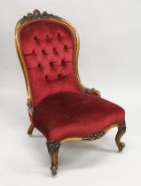 A VICTORIAN WALNUT FRAMED BUTTON BACK ARMCHAIR, on carved cabriole legs with castors.