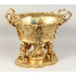 A VERY GOOD GILT BRONZE OVAL TWO HANDLED CENTREPIECE with fruiting vines and cupid supports. 17ins