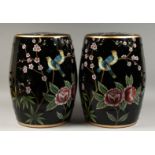 A PAIR OF CHINESE BLACK POTTERY BARREL SEATS painted with birds and flowers. 17ins high.