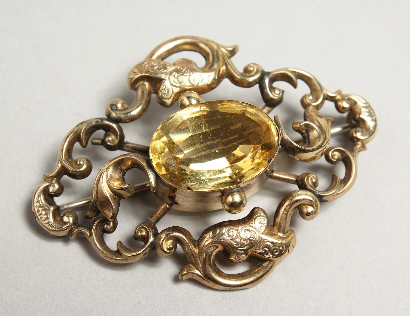 A GOLD AND CITRON BROOCH.