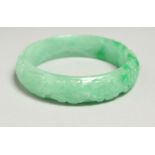 A CARVED JADE BANGLE, 7cm diameter.