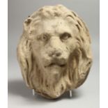 A CARVED STONE LION'S HEAD ROUNDEL, possibly Roman. 9ins x 7ins.