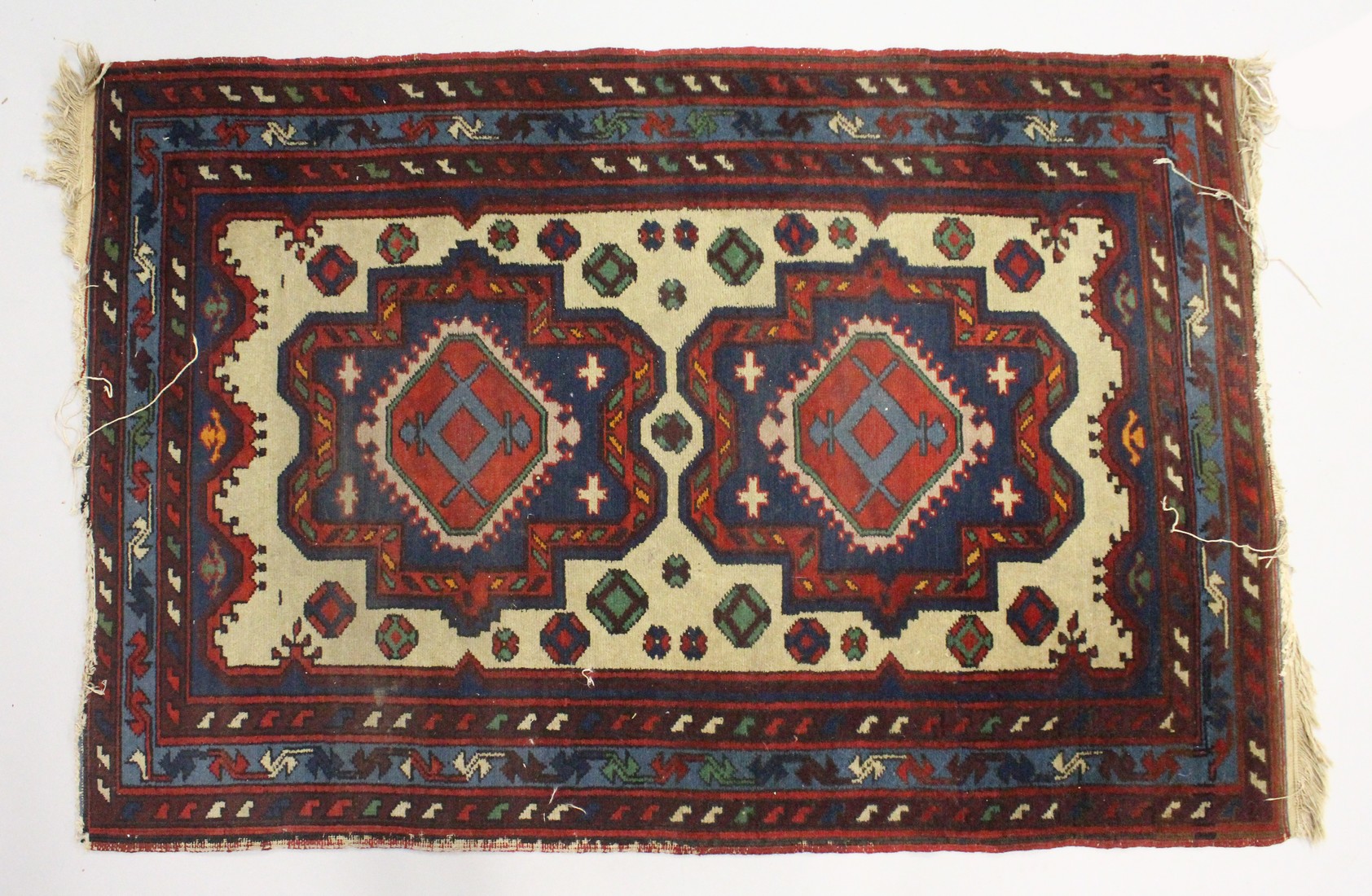 A SMALL PERSIAN RUG, cream ground with two large medallions. 4ft x 2ft 8ins.