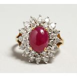 A GOLD CABOCHON RUBY AND DIAMOND CLUSTER RING.