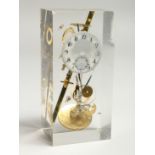 A CLOCK SCULPTURAL PIECE of watch movements, in a Perspex case. 5.25ins high.