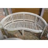 A teak curved garden bench.