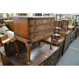 A walnut three drawer chest on cabriole legs.