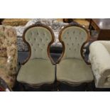 A pair of Victorian walnut framed button upholstered bedroom chairs.