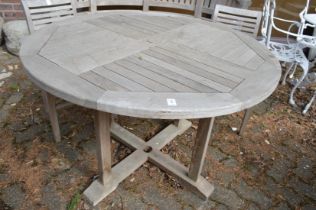 A circular teak garden table.