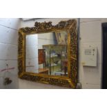 A decorative Chinese carved and pierced gilt framed mirror.