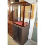 A glass display cabinet on painted base.