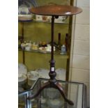 A mahogany tripod table with adjustable top.