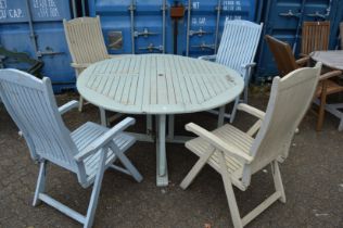 A painted circular garden table and four folding chairs.
