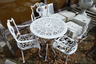 A white painted aluminium circular patio table and three armchairs.