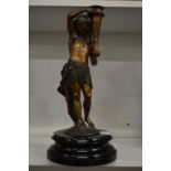 A spelter lamp base modelled as an Egyptian man holding a torch.