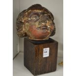 A 17th century carved limewood cherub's head on later stand.