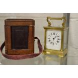 A brass carriage clock with leather carrying case and key.