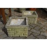 A pair of square shaped composite garden planters.