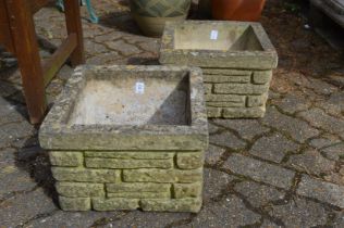 A pair of square shaped composite garden planters.