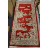 A Chinese red ground pictorial rug.