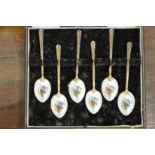 A set of six silver and enamel backed coffee spoons.