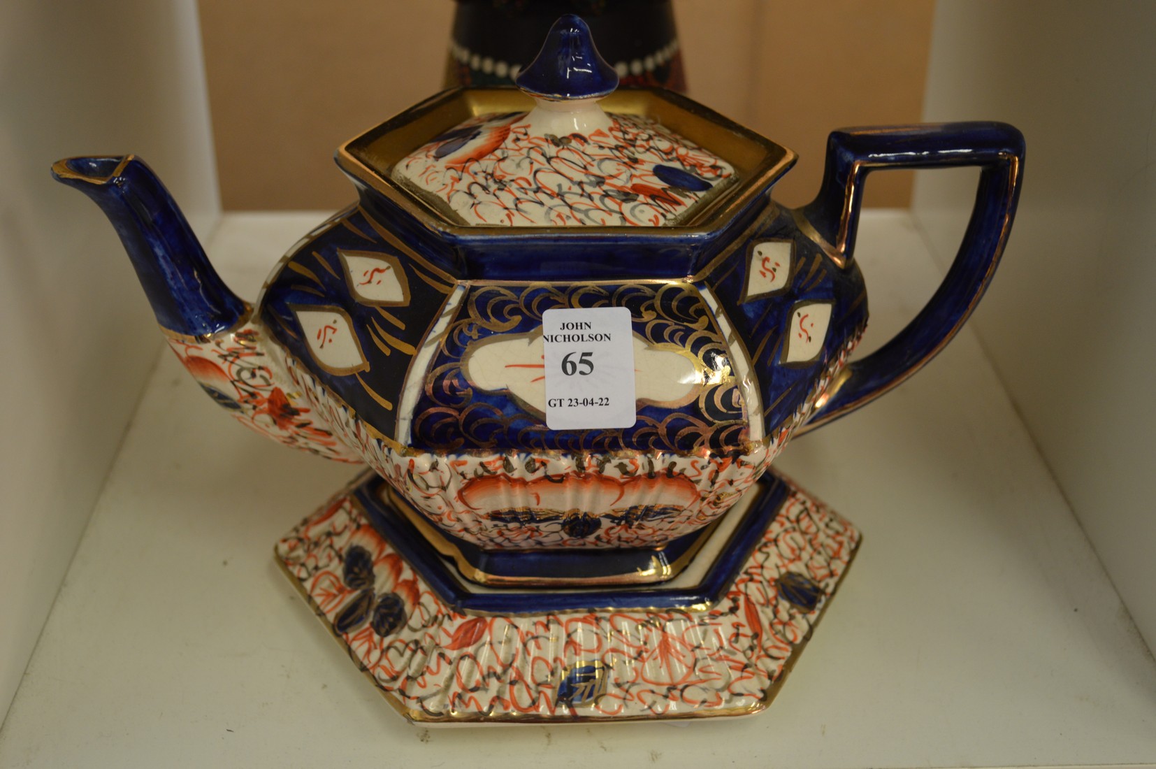 A lustre teapot on stand.