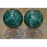 A pair of unusual faux marble spheres on perspex bases.