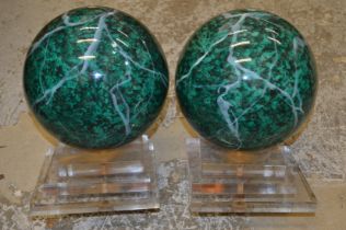 A pair of unusual faux marble spheres on perspex bases.