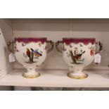 A good pair of porcelain twin handled pedestal ice pails decorated with exotic birds.