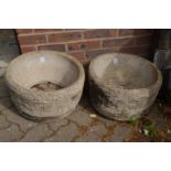 A pair of circular composite garden planters.