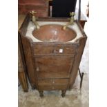 A mahogany wash basin containing a copper bowl with brass taps (AF).