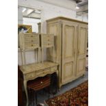 A decoratively painted French bedroom suite comprising two door wardrobe, dressing table and a